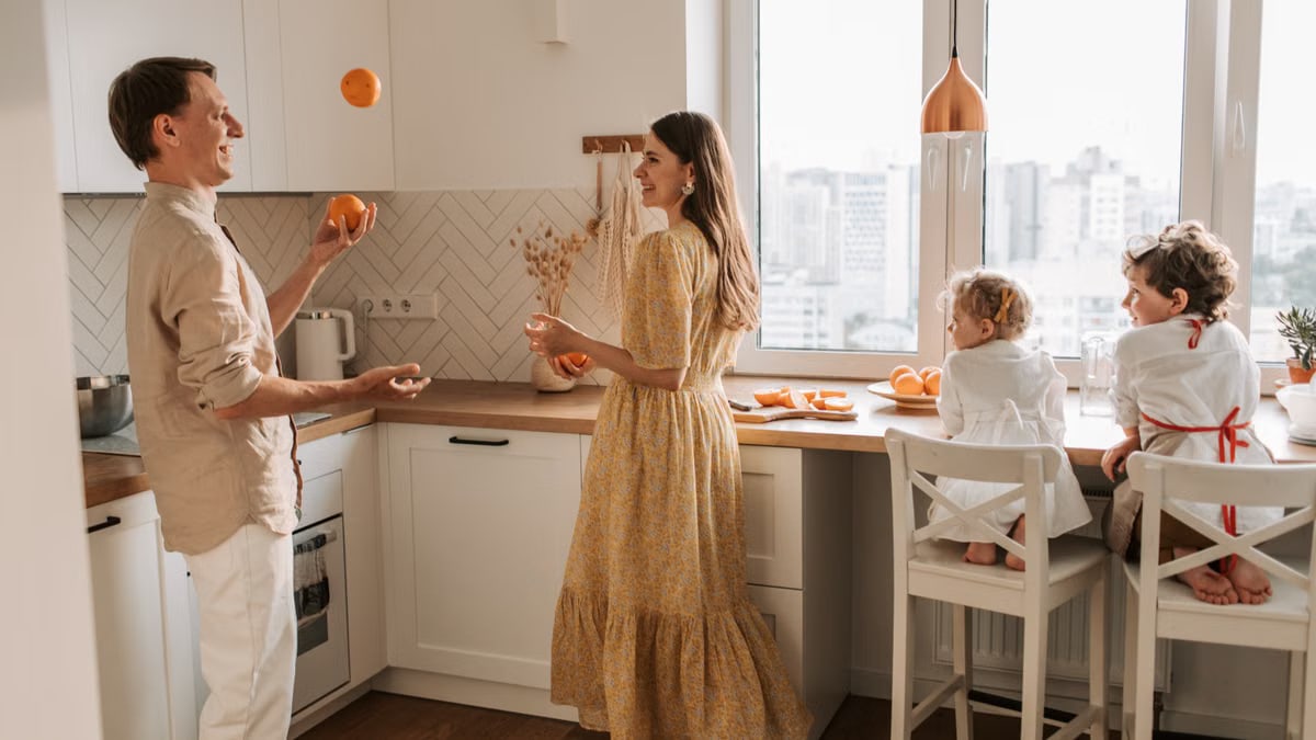 Joyful family scene with parents and children playing in a bright kitchen.